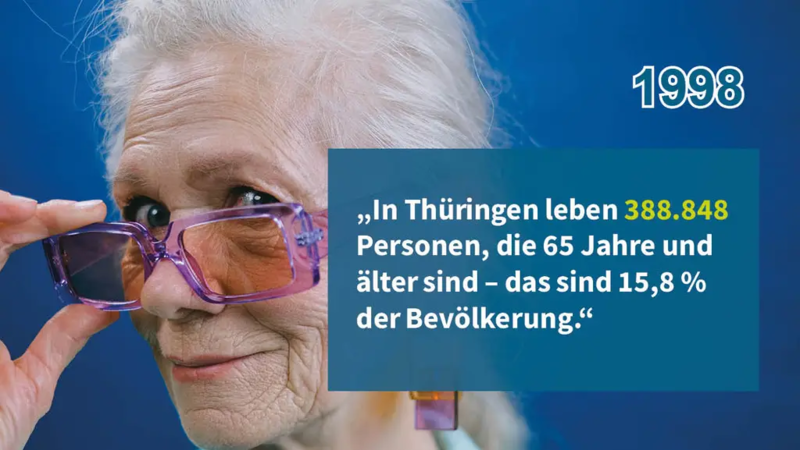 ältere Frau mit weißgrauen Haaren blickt über ihre lila Brille